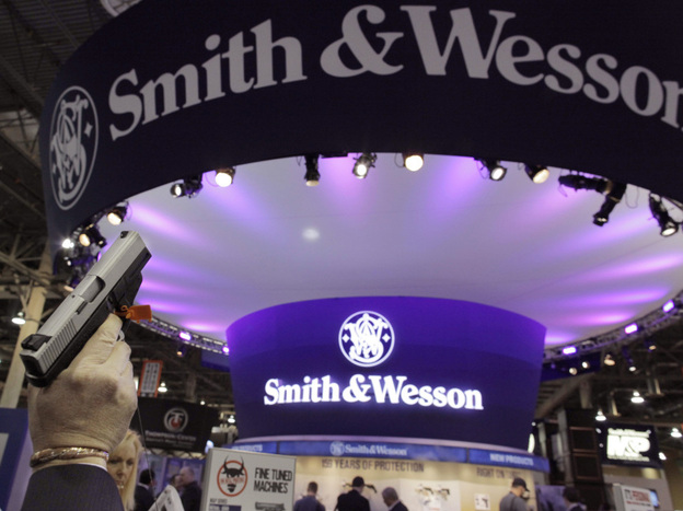 A retailer examines a Smith & Wesson hand gun at the Shooting, Hunting and Outdoor Trade show in Las Vegas, Jan. 18, 2011.