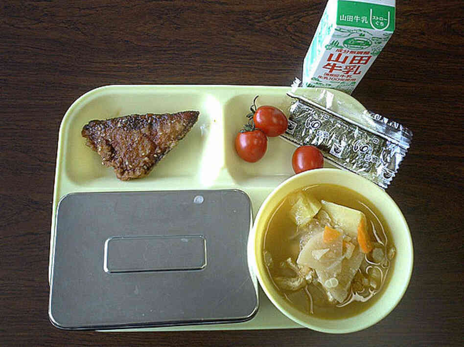 Sendai, Japan, 2004. Fried fish, tomatoes, seaweed, milk, miso soup and rice in a metal container. 