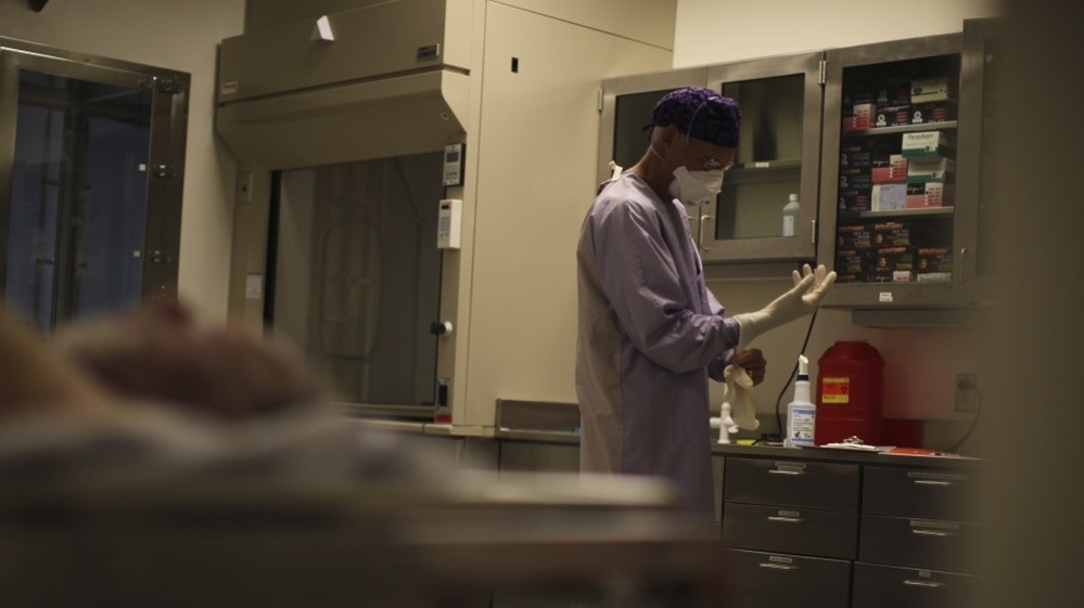 A forensic pathologist prepares for an autopsy at The New Mexico Office of the Medical Investigator.