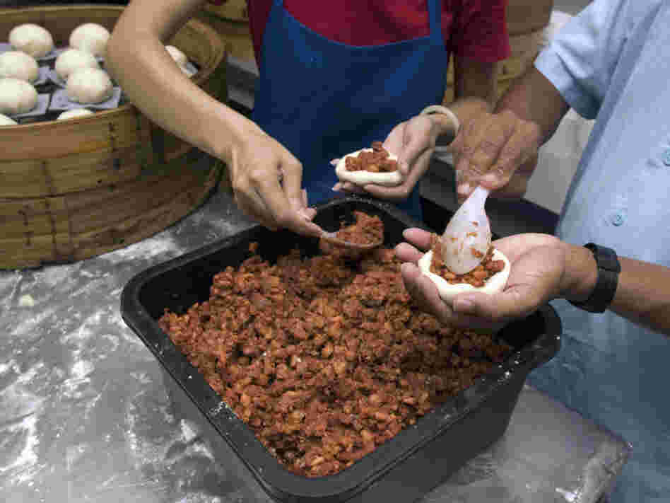 Workers at Shay Shay Tien make pow, placing the meat filling onto discs of dough that will go in a steamer basket