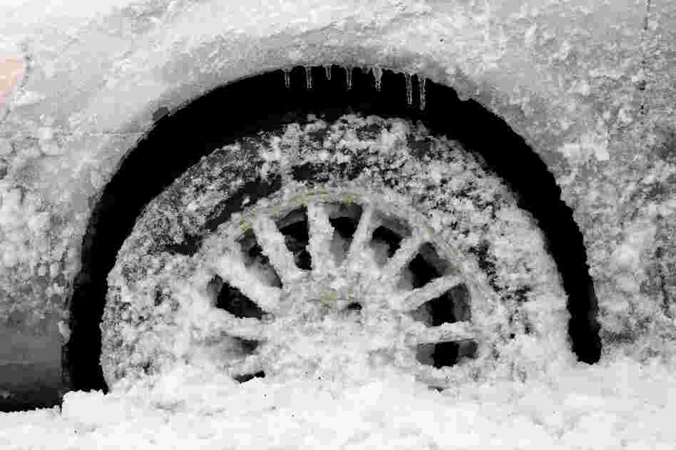 Icicles, snow and slush cover the wheel area of a parked vehicle in Newark, N.J. 