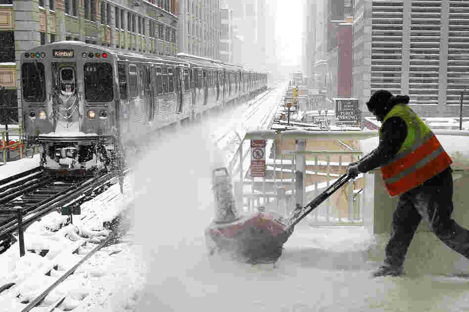 A Chicago Transit Authority employee removes snow from an elevated train platform during the blizzard Wednesday. 