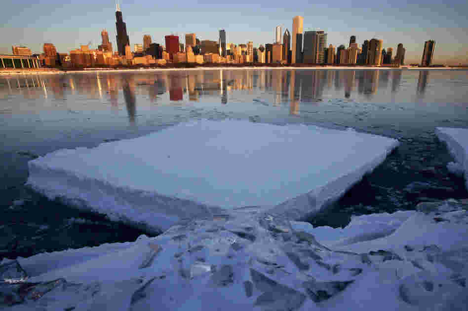 The Chicago skyline is reflected on a thin layer of ice in Monroe Harbor on Thursday, one day after a blizzard dumped the third largest snowfall in Chicago's history. 