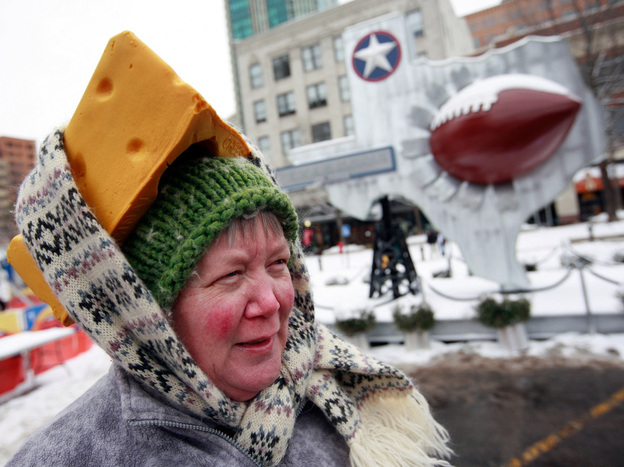 Caroline Fralia uses a scarf to secure her foam cheesehead hat Friday in Sundance Square in Fort Worth, Texas.