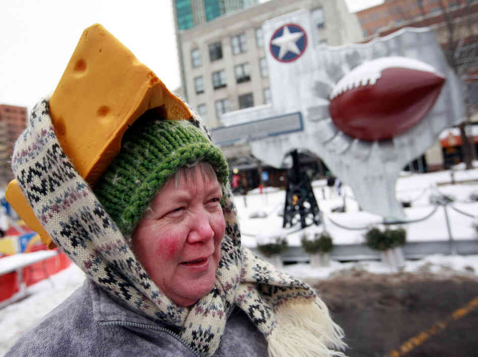 Caroline Fralia uses a scarf to secure her foam cheesehead hat Friday in Sundance Square in Fort Worth, Texas.