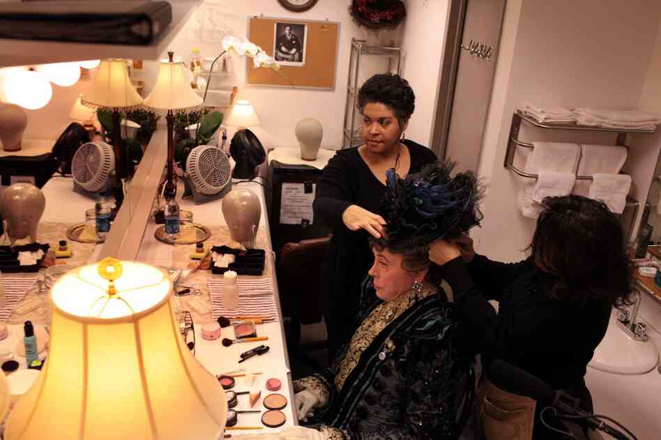 It takes two people to pin on Lady Bracknell's hat: Nellie Laporte and her assistant Yolanda Ramsay.