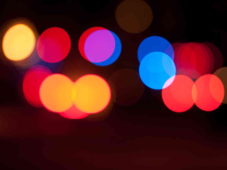 Blurred police and ambulance sirens at night.