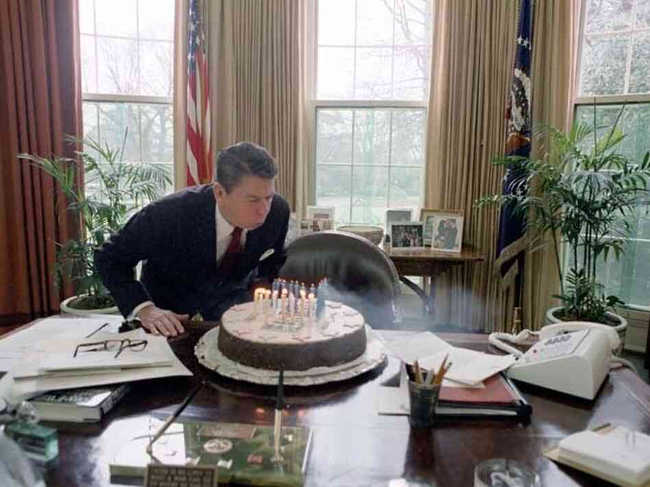 President Reagan blowing out candles on cake while celebrating his birthday in the Oval Office. Feb. 5, 1982. President Reagan blowing out candles on cake while celebrating his birthday in the Oval Office. Feb. 5, 1982.