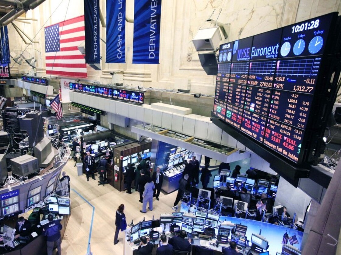 Traders work at the New York Stock Exchange on Thursday as a merger with the German exchange, Deutsche Boerse, moved forward.