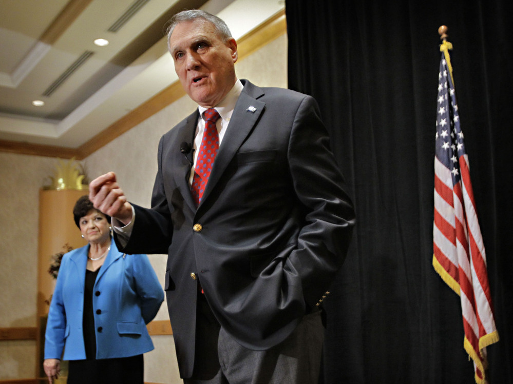 Sen. Jon Kyl in Phoenix announcing his retirement as wife, Caryll Kyle, listens, Feb. 10, 2011.