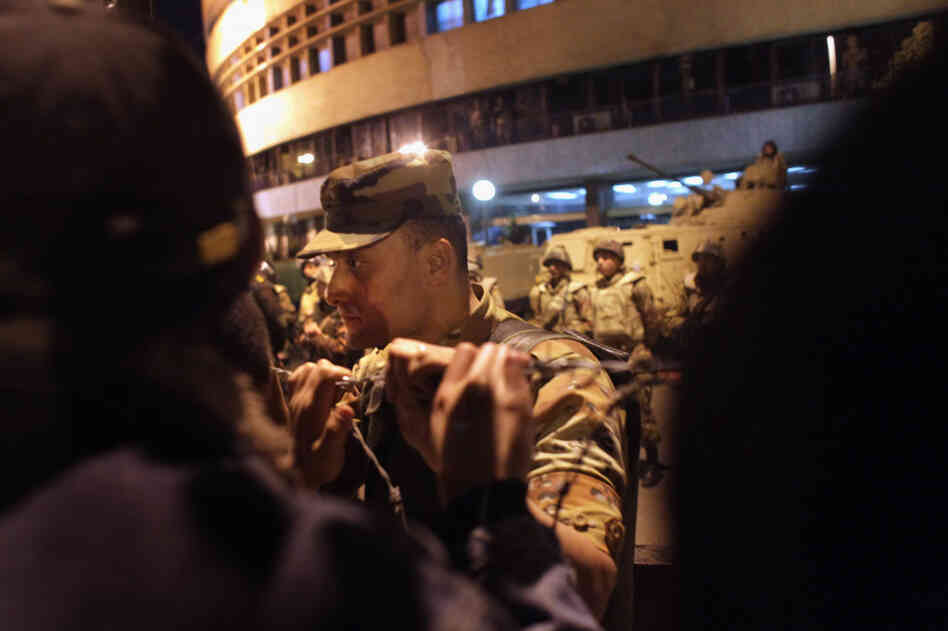 An Egyptian army officer speaks to anti-government protesters outside the national television building after President Mubarak's Thursday address to the nation. 