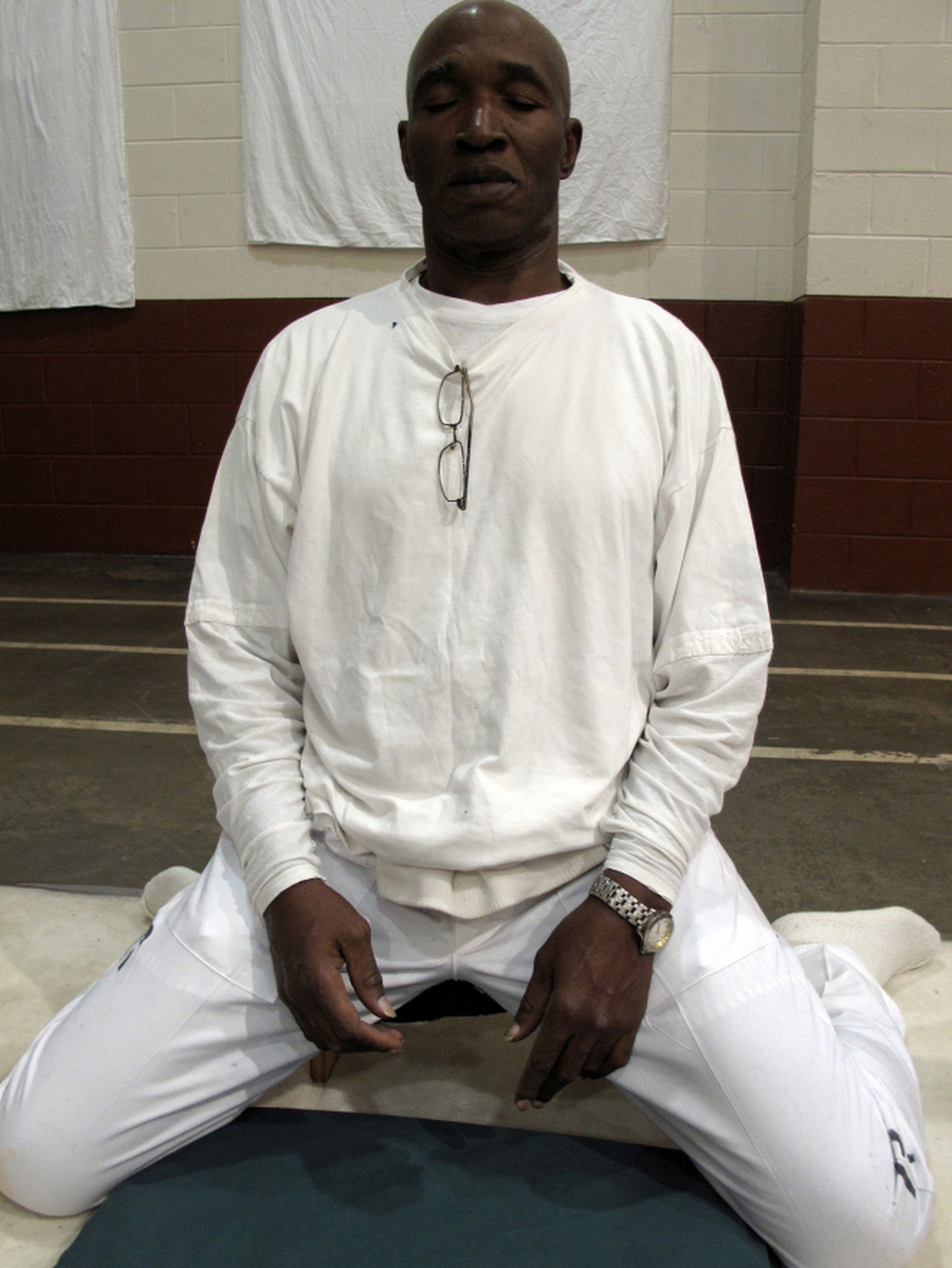 Convicted murderer Johnny Mack Young in the meditation stance he keeps for nearly 10 hours a day during the 10-day silent meditation course. Officials say the meditation program is reducing violence at Alabama's highest security lockup. "It changed my life," Young says.