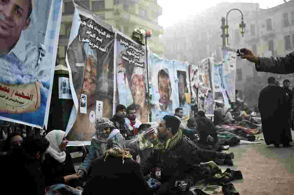 In the early hours Friday, anti-government demonstrators rest in front of posters of people killed during the latest political crisis. 