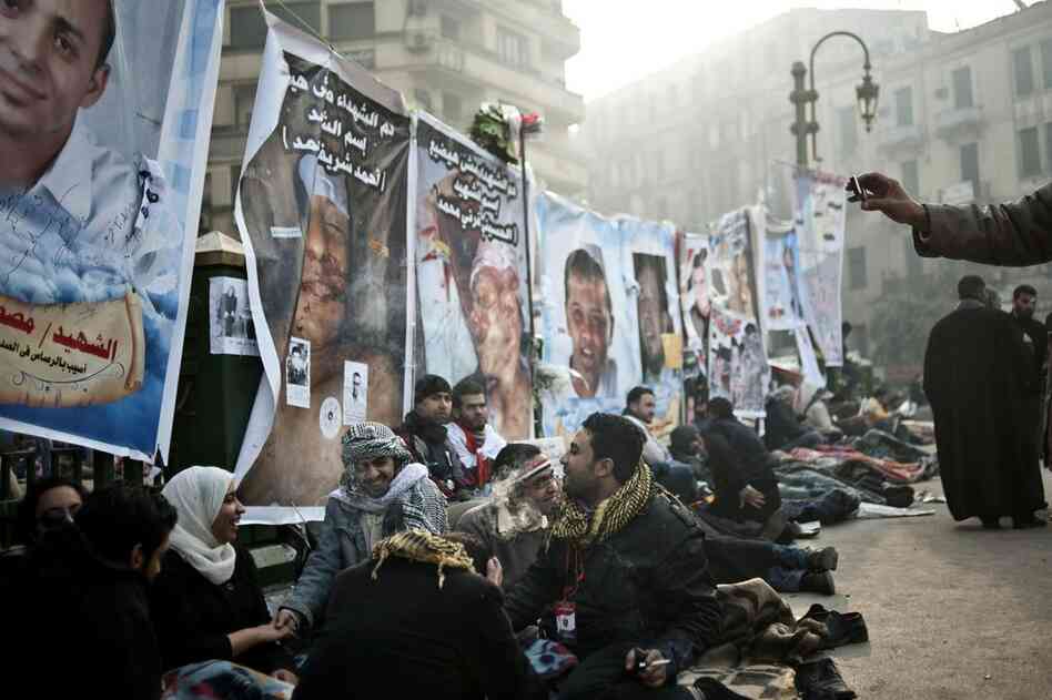 In the early hours Friday, anti-government demonstrators rest in front of posters of people killed during the latest political crisis. 