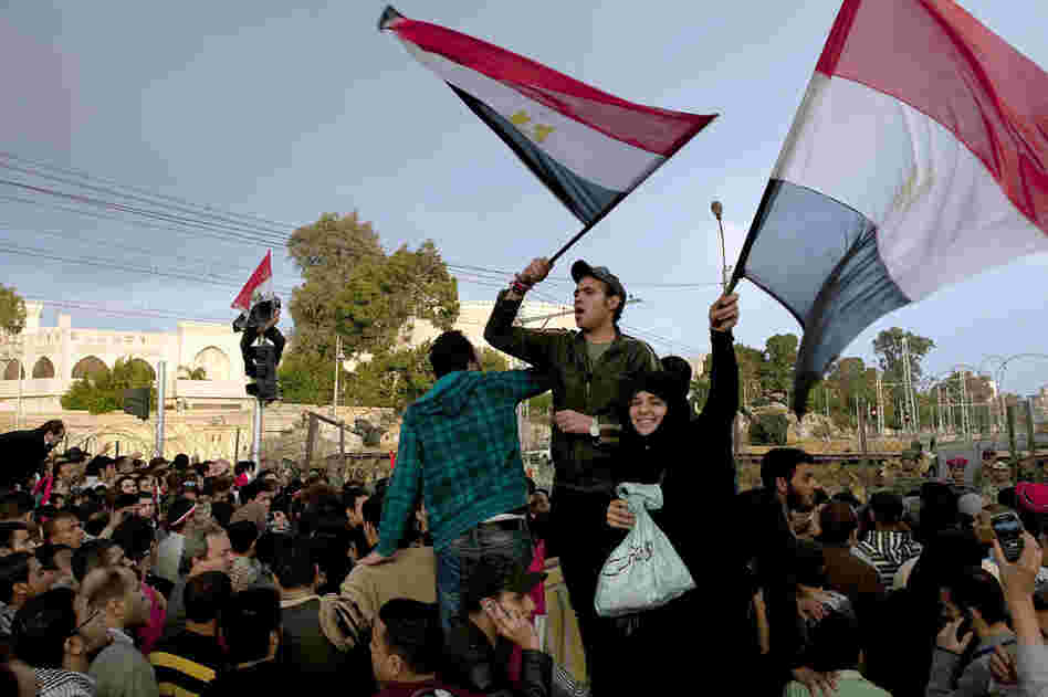 Protesters wave flags outside the Presidential Palace on Friday. Cairo's streets exploded in celebration when Mubarak stepped down after three decades of autocratic rule. 