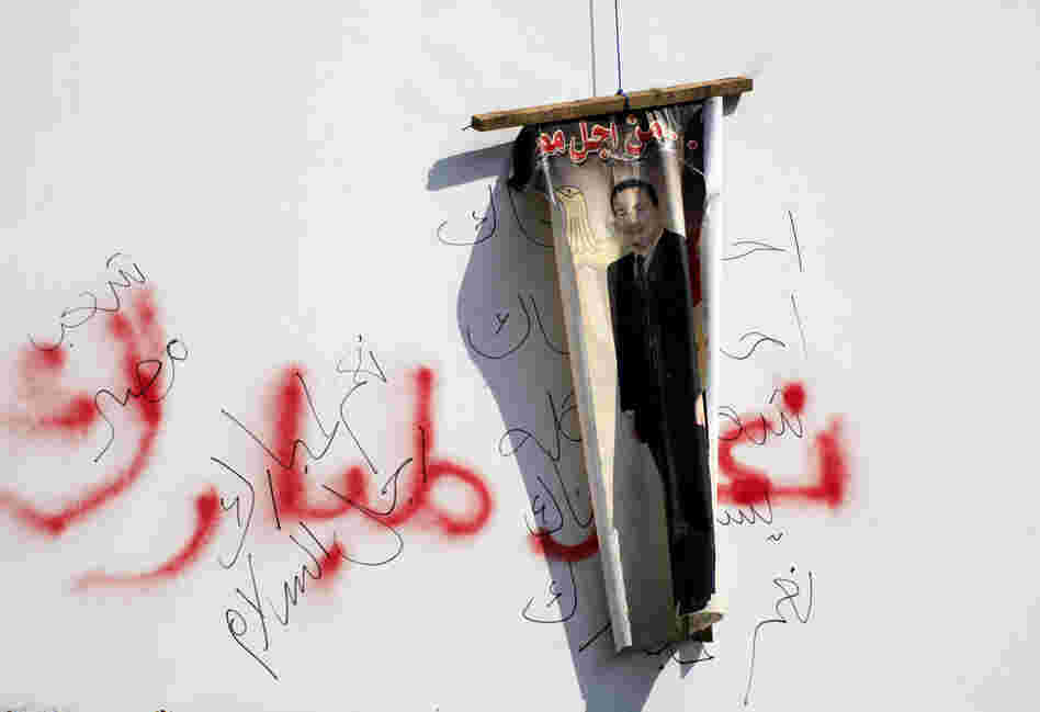 An anti-Mubarak poster hangs over graffiti endorsing the president. Clashes between anti-government protesters and Mubarak supporters have thrown Cairo into violence. 