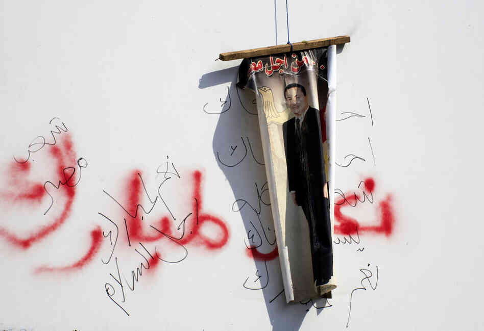 An anti-Mubarak poster hangs over graffiti endorsing the president. Clashes between anti-government protesters and Mubarak supporters have thrown Cairo into violence. 