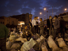 Egyptians stand on sacks of garbage collected after cleaning Tahrir Square in downtown Cairo on Saturday. Egyptians stand on sacks of garbage collected after cleaning Tahrir Square in downtown Cairo on Saturday.
