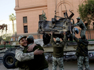 Soldiers hug as others remove the wreckage of a car burned during the uprising at Cairo's Tahrir Square. Soldiers hug as others remove the wreckage of a car burned during the uprising at Cairo's Tahrir Square.