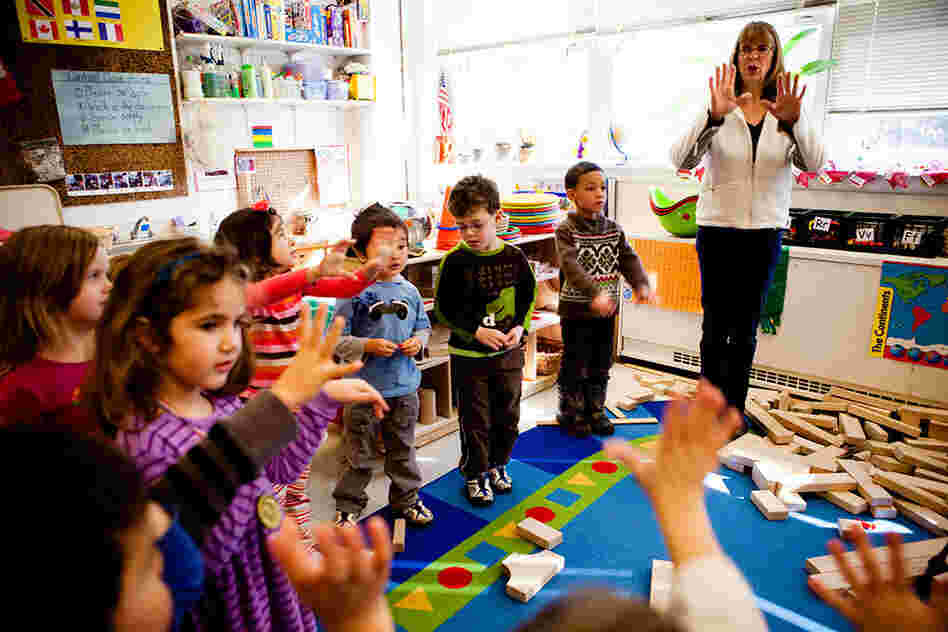 Cathie Morton, a teacher at the Clara Barton  Center for Children, leads the kids in a clapping exercise to signal that it is time to shift gears and start cleaning up.