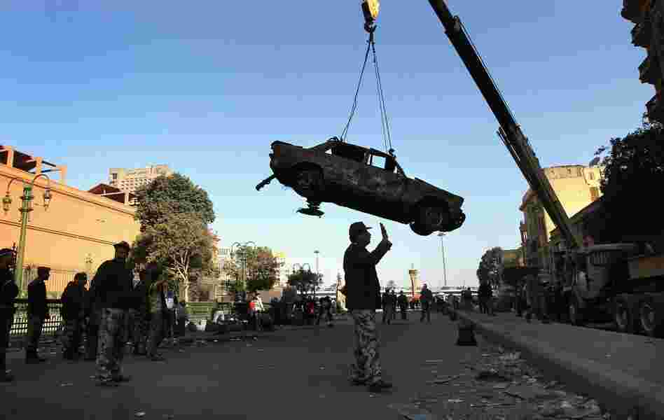 Soldiers remove a car burnt during clashes in Tahrir Square. 