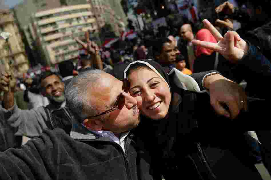 Egyptians embrace while celebrating Mubarak's resignation. 
