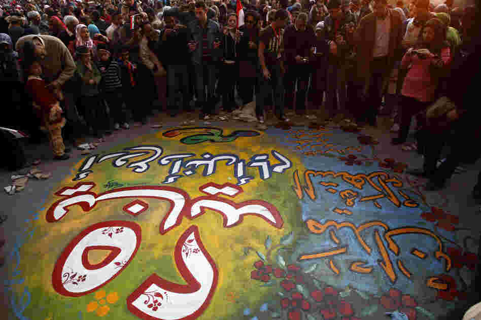 Egyptians gather around graffiti that reads, "January 25, Egypt's greatest and noblest day, Martyrs Square" in Tahrir Square. 