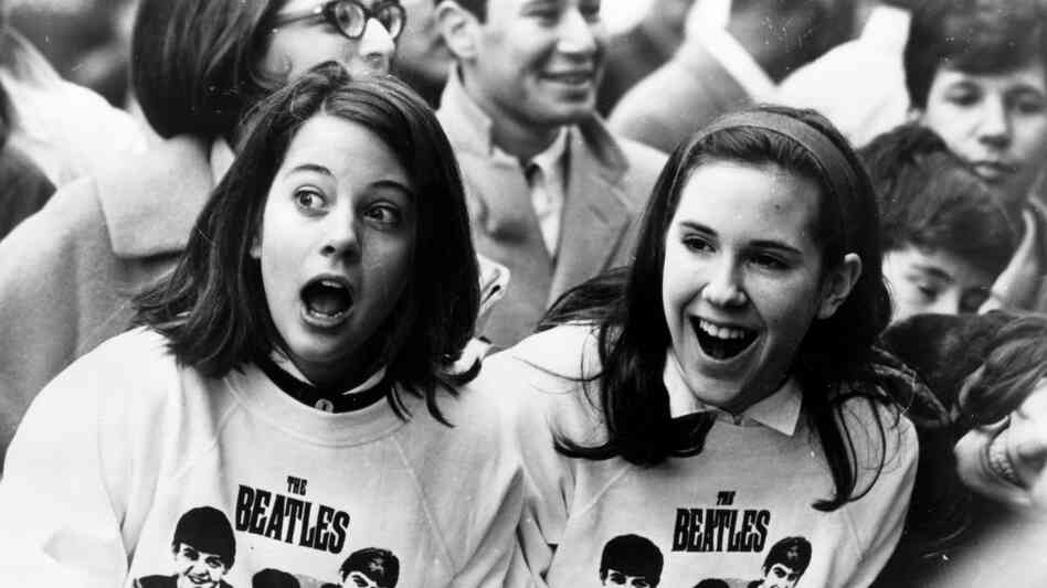 Two Beatles fans welcome the group as they arrive in New York in February 1964. Two Beatles fans welcome the group as they arrive in New York in February 1964.