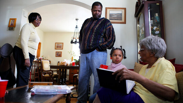Robert  Adams, with his daughter Lucy,  grandmother Lucy Stith,  90,  right, and mother, Hattie  Adams. They look through old  family photographs at Hattie Adams' house near historic Anacostia.