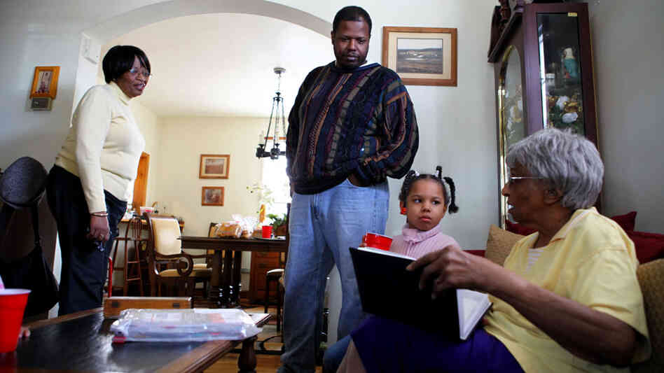 Robert  Adams, with his daughter Lucy,  grandmother Lucy Stith,  90,  right, and mother, Hattie  Adams. They look through old  family photographs at Hattie Adams' house near historic Anacostia.