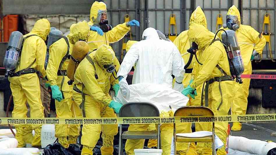 Members of a hazardous materials response team help to remove a hazardous materials suit from an investigator who had emerged from the U.S. Post Office in West Trenton, N.J., on Oct. 25, 2001. The post office was closed after two letters containing anthrax were traced back to this facility. Members of a hazardous materials response team help to remove a hazardous materials suit from an investigator who had emerged from the U.S. Post Office in West Trenton, N.J., on Oct. 25, 2001. The post office was closed after two letters containing anthrax were traced back to this facility.