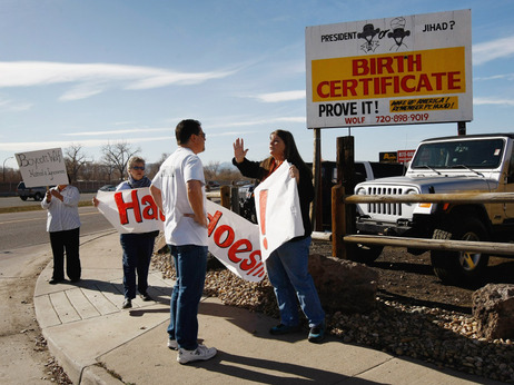 Obama supporter Mary Schaeffer argues with critic Gary Henderson near a birther billboard, November 2009. Obama supporter Mary Schaeffer argues with critic Gary Henderson near a birther billboard, November 2009.