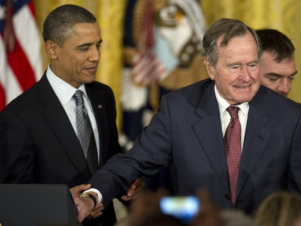 President Obama assists former President George H.W. Bush during todays Medal of Freedom ceremony at the White House.