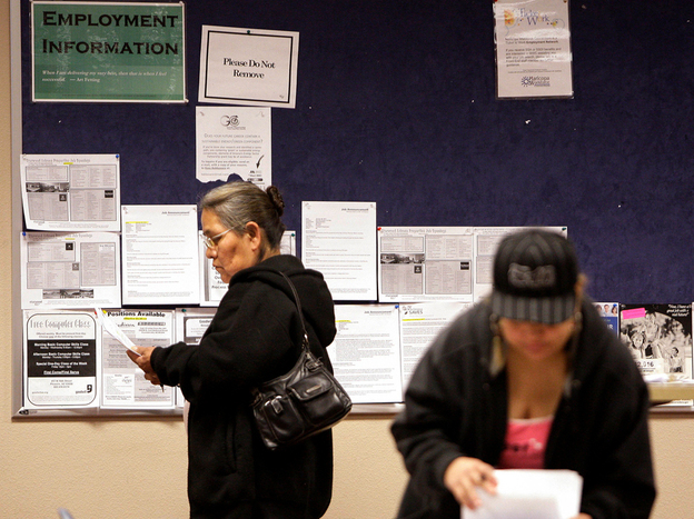 Job seekers read their resumes as they stand near a bulletin board with job posting fliers on it at the Arizona Workforce Connection West Valley Career Center in Phoenix. Foreign-born workers have had better employment prospects than U.S. natives.