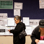 Job seekers read their resumes as they stand near a bulletin board with job posting fliers on it at the Arizona Workforce Connection West Valley Career Center in Phoenix. Foreign-born workers have had better employment prospects than U.S. natives.