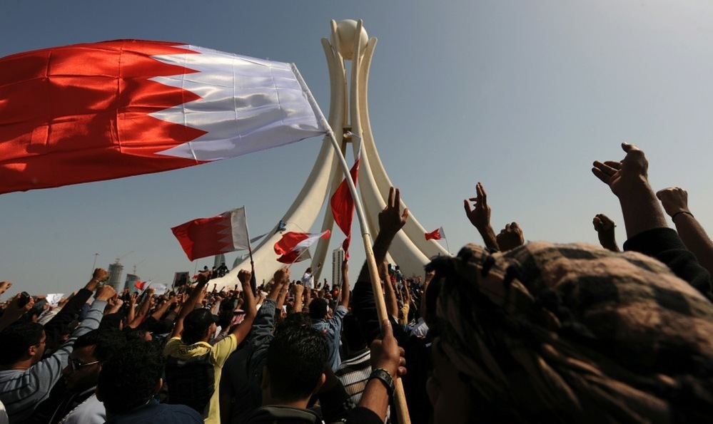 Bahraini protesters wave the national flag and chant slogans as they gather Wednesday at Pearl Square in the capital city of Manama.