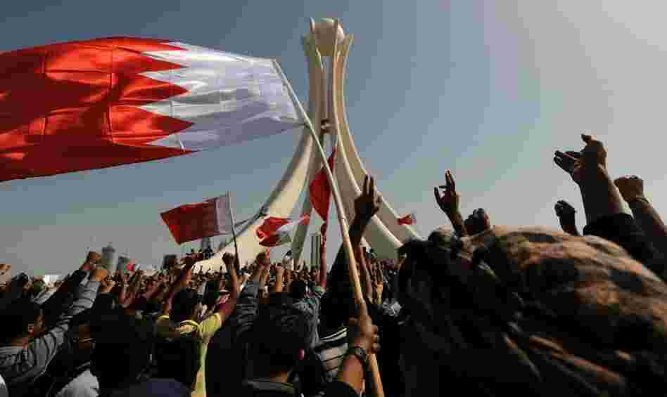 Bahraini protesters wave the national flag and chant slogans as they gather Wednesday at Pearl Square in the capital city of Manama.