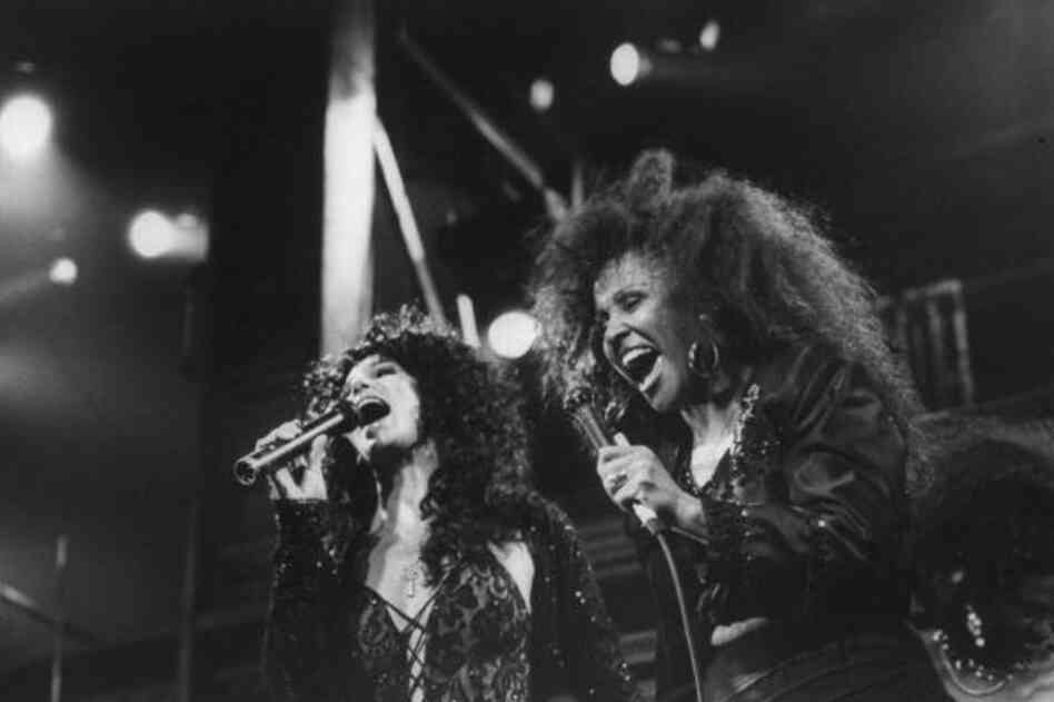 Love performs with Cher at Fox Theater in 1989. After hitting rock bottom taking up work as a house cleaner, Love made her way back to the stage preforming in New York and Los Angeles and singing backup vocals for Cher and U2. 