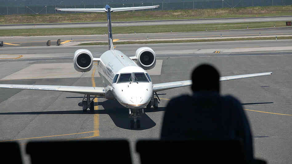A passenger waits in a lounge overlooking the tarmac at LaGuardia Airport in New York. A passenger waits in a lounge overlooking the tarmac at LaGuardia Airport in New York.