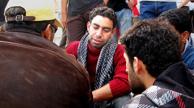 Hassan Issa, in red, the son of one  of the people killed today in Bahrain when police broke up a camp of protesters. He says his father, Issa Abdel Hassan was shot and killed by  police as they tried to make their way to Pearl Square, which riot police were  clearing with teargas, clubs and other weapons. The son said, "I was supposed  to be the martyr, not him."