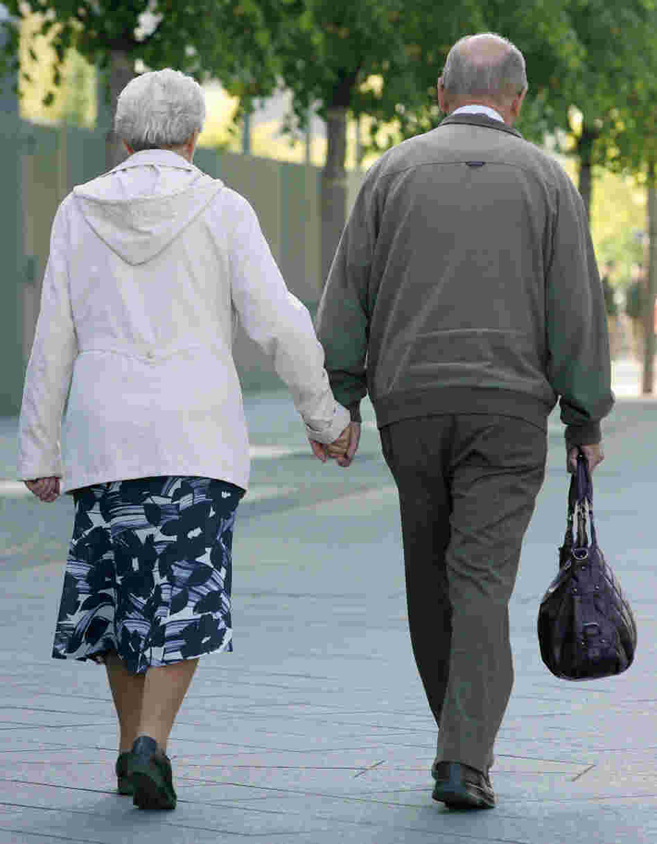An elderly couple holds hands while walking along a Berlin street. A recent study showed that walking grows the region of the brain that archives memories.