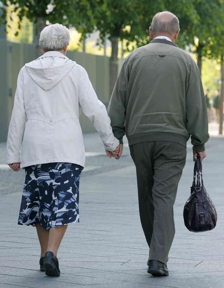 An elderly couple holds hands while walking along a Berlin street. A recent study showed that walking grows the region of the brain that archives memories.