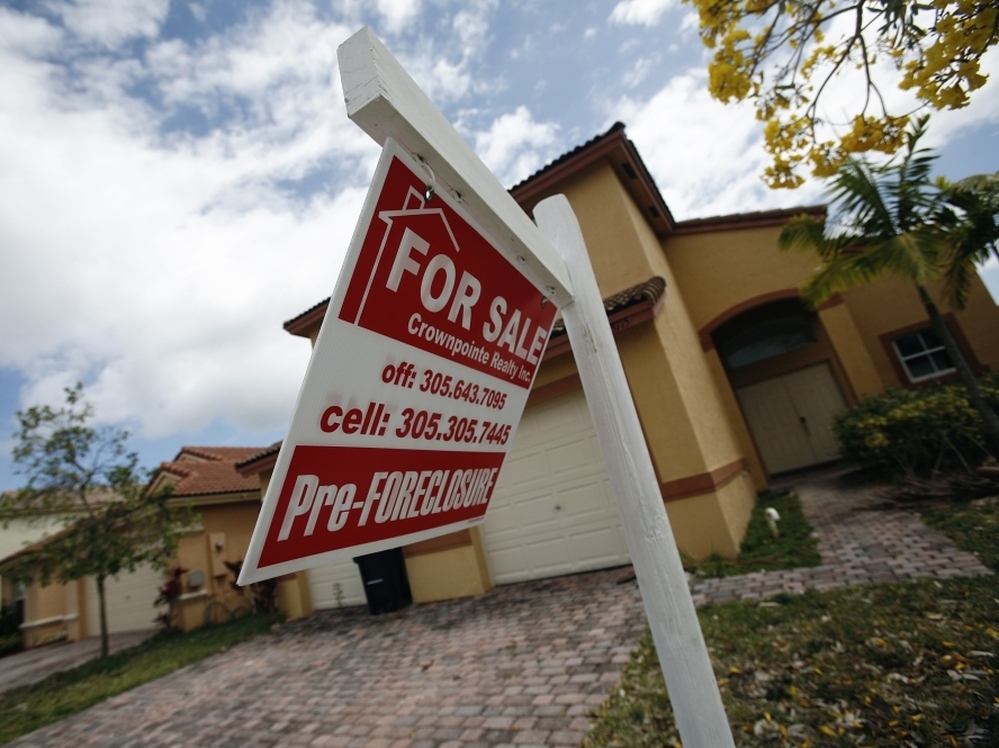 A for sale sign hangs in front of a Homestead, Fla., home. In certain places more than half of the homes sold are in one stage of foreclosure or another.