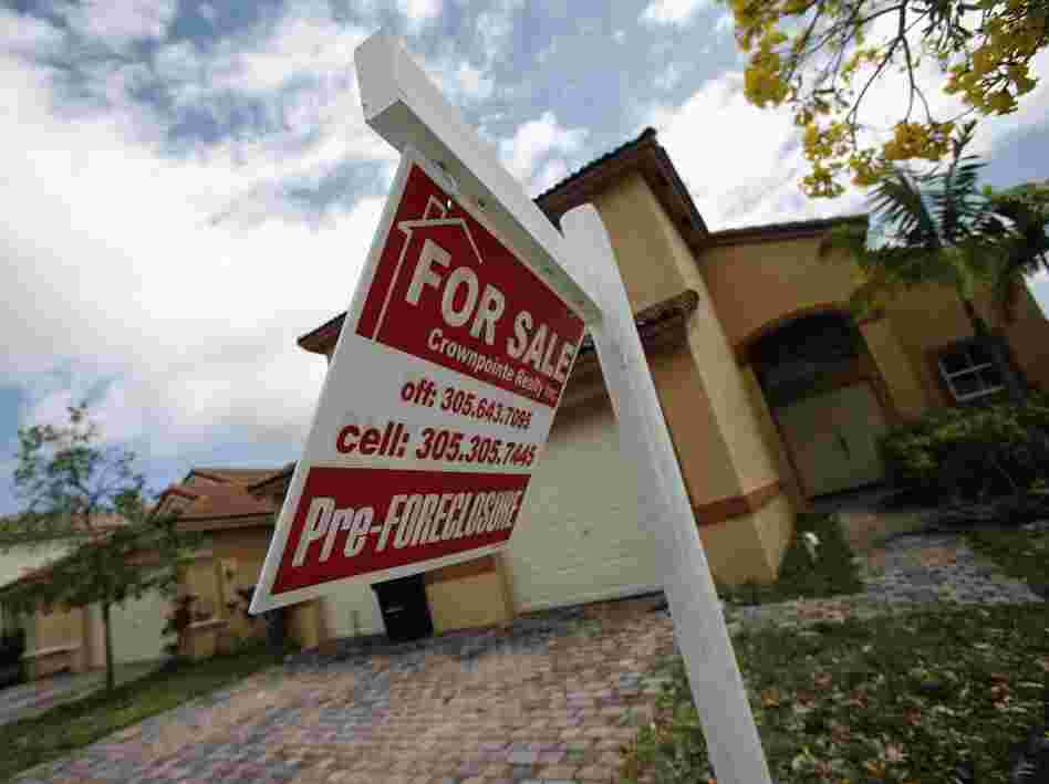A for sale sign hangs in front of a Homestead, Fla., home. In certain places more than half of the homes sold are in one stage of foreclosure or another.