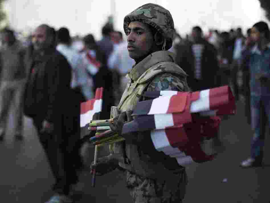 An Egyptian soldier greeted demonstrators with national flags today in Cairo's Tahrir Square.
