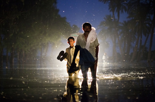 A Pakistani man and boy,  displaced by floods, walk through flood waters on Aug. 22, 2010 in the village of Baseera near Muzaffargarh in Punjab, Pakistan.