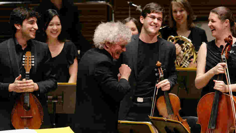 The Ensemble ACJW, conducted by Sir Simon Rattle (center), features musicians from the Academy, sponsored by Carnegie Hall and the Juilliard School. The violist to the right of Rattle is Nathan Schram.