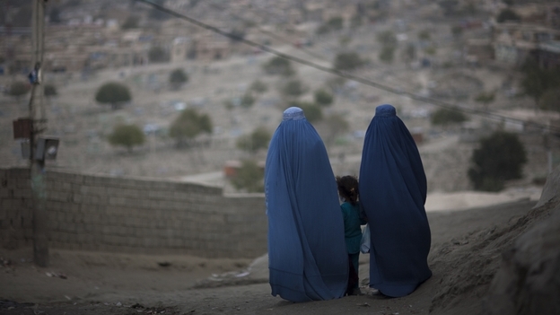 A girl stands among Afghan women clad in burqas  in Kabul last October.