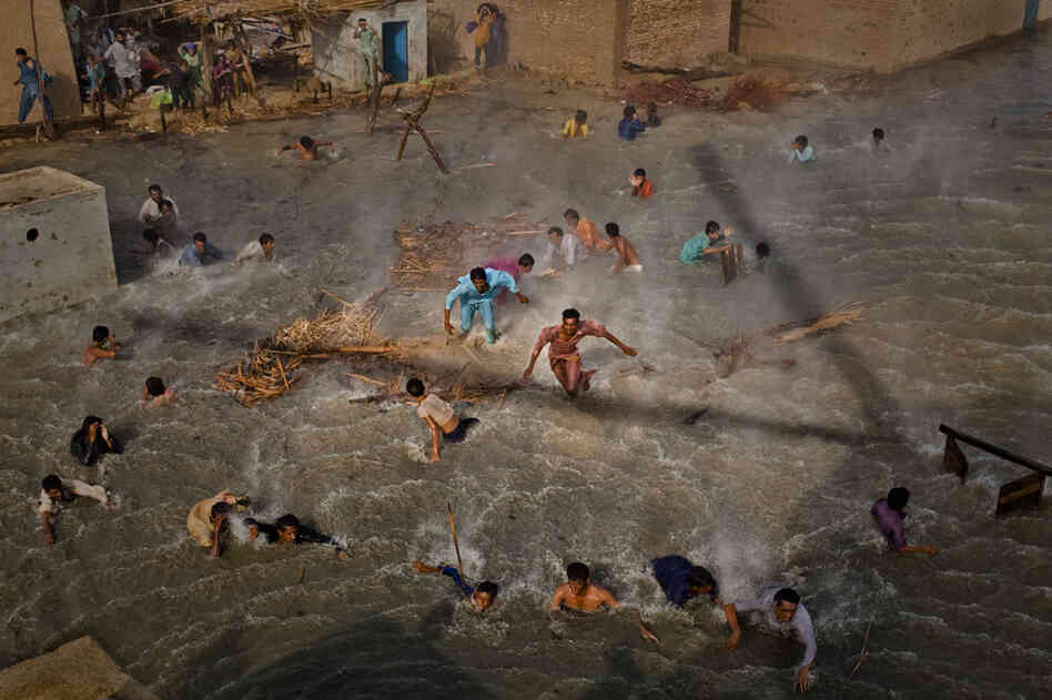 Flood victims scramble for food rations as they battle the downwash from a Pakistan Army helicopter during relief operations on September 13, 2010 in the village of Goza in Dadu district in Sindh province, Pakistan.