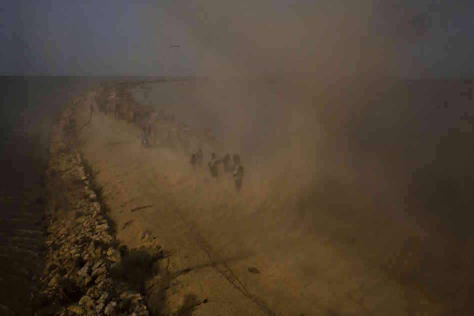 Flood victims scramble for food rations, dropped by Pakistan Army soldiers, as they battle the downwash from a Pakistan Army helicopter during relief operations on September 13, 2010 on the Suprio Bund near the village of Goza in Dadu district in Sindh province, Pakistan.